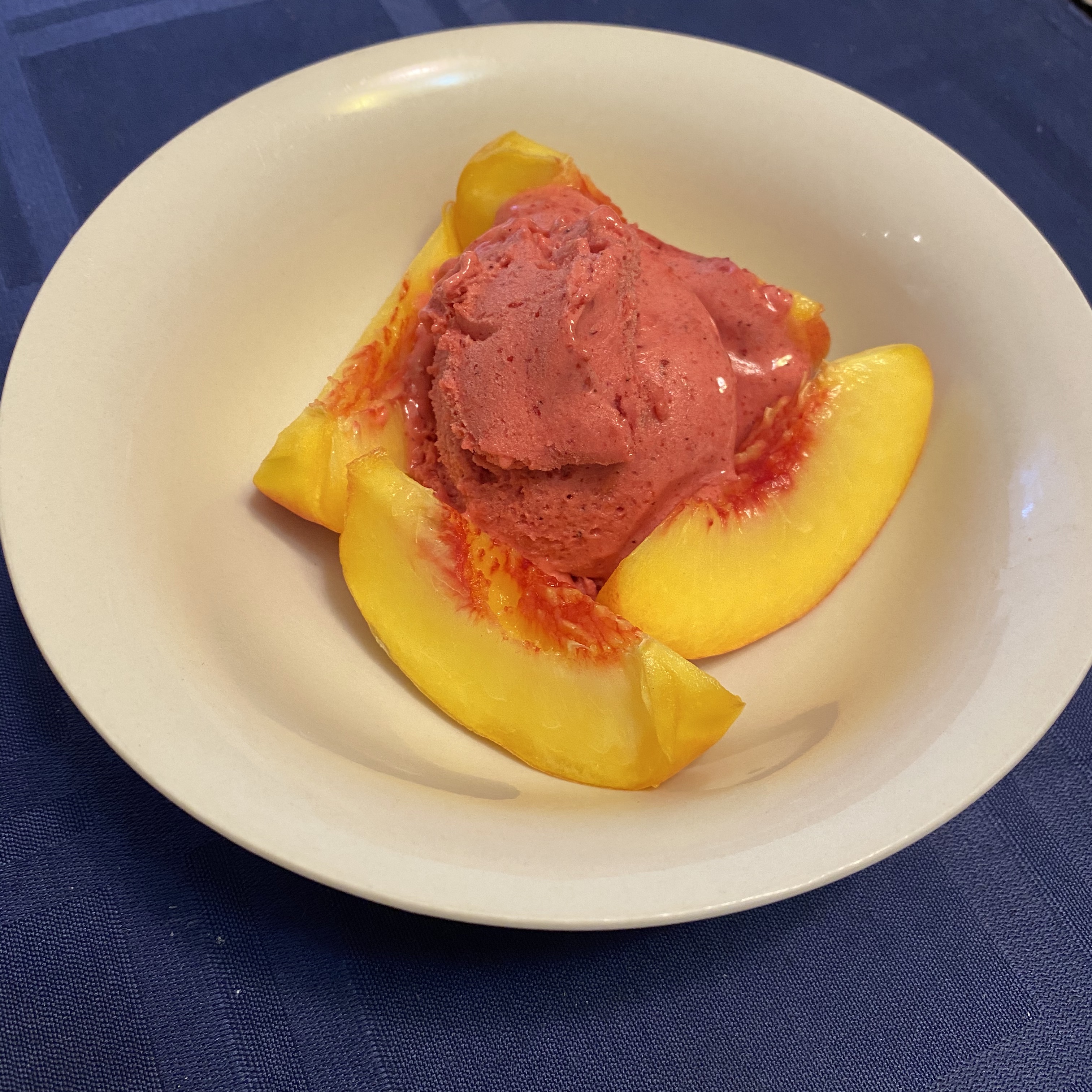 Gluten and dairy-free Raspberry Ginger Lime Gelato paired with fresh peaches - a refreshing and indulgent treat.